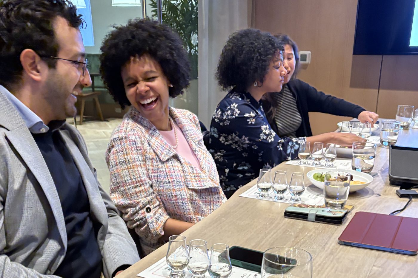 Colleagues laughing over tasting flights at a corporate masterclass